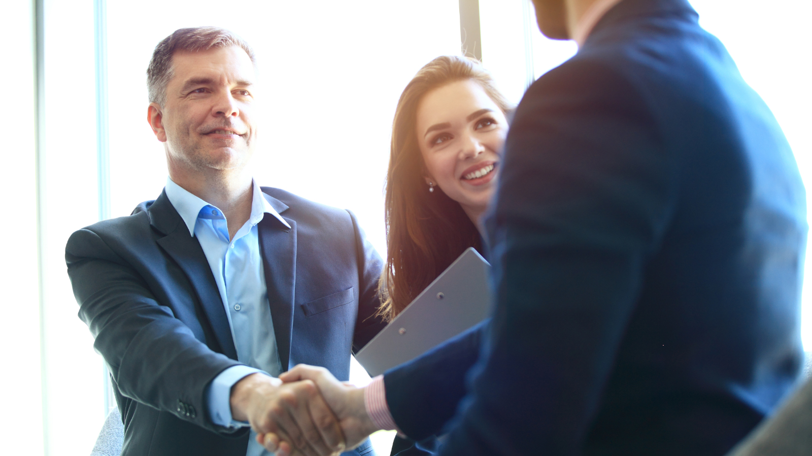 business man and woman shake hands with client