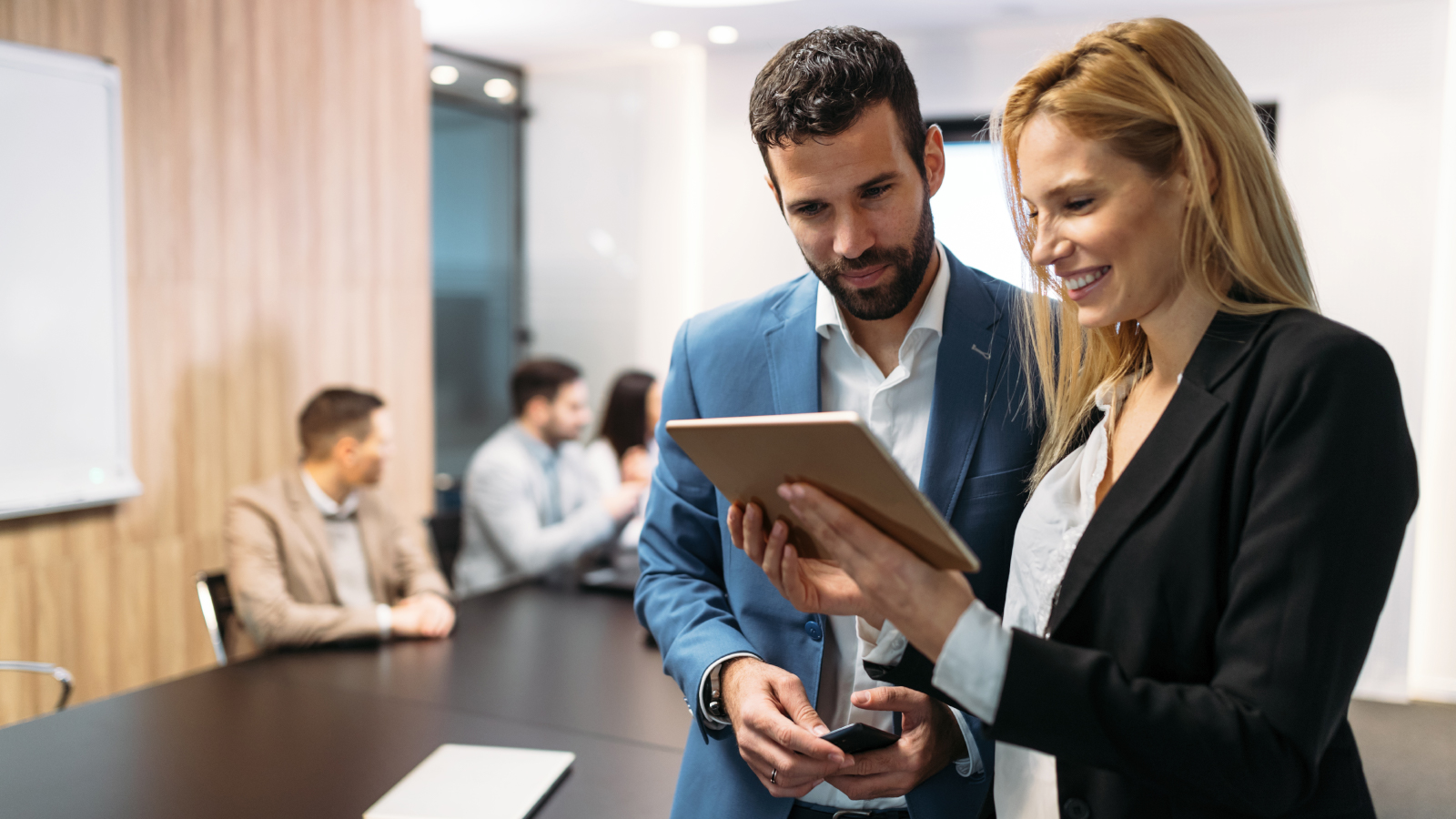 Business man and woman reviewing financials on tablet
